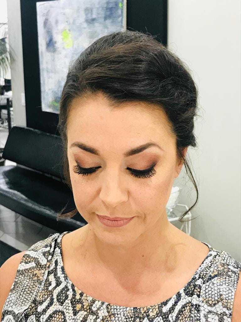 Woman with elegant makeup and updo hairstyle in a salon.
