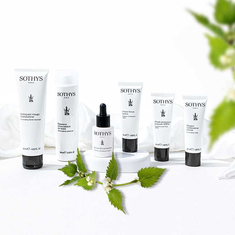 Sothys skincare products arranged with green leaves on a white surface.